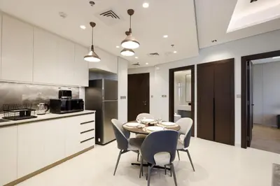 a kitchen and dining room with a table and chairs at High-Floor 1BR with Burj Khalifa View Prime Location in Dubai