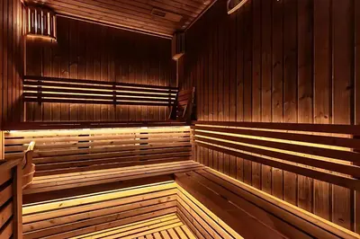 an empty sauna with wooden walls and wooden floors at High-Floor 1BR with Burj Khalifa View Prime Location in Dubai