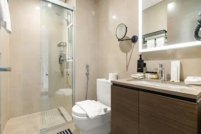 a bathroom with a toilet and a shower and a sink at Elegant 1BR Stay in Sobha Creek Luxury Apartment Near Dubai Canal in Dubai