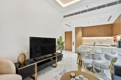 a living room with a large flat screen tv at Heaven Crest Vacation Homes - One Bedroom City View Balcony in Azizi Riviera in Dubai