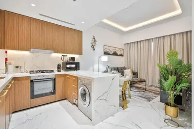 a kitchen and living room with a washer and dryer at Heaven Crest Vacation Homes - One Bedroom City View Balcony in Azizi Riviera in Dubai