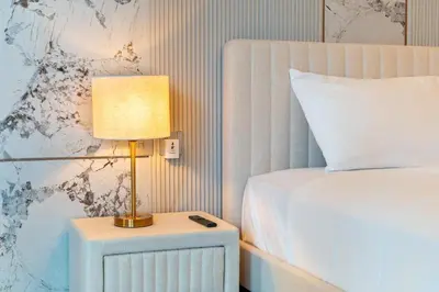 a lamp on a night stand next to a bed at Elite apartment near Dubai Mall in Dubai