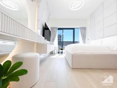 a white bedroom with a large bed and a staircase at Luxury Living in Azizi Riviera l Cozy Balcony in Dubai