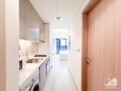 a white kitchen with a sink and a stove at Luxury Living in Azizi Riviera l Cozy Balcony in Dubai
