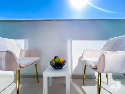 two chairs and a bowl of fruit on a table at Luxury Living in Azizi Riviera l Cozy Balcony in Dubai
