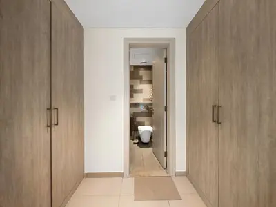 a bathroom with wooden cabinets and a toilet at Palm Jumeirah Beachfront 1 Bedroom Apartment with Rooftop Infinity Pool and Atlantis Views in Dubai