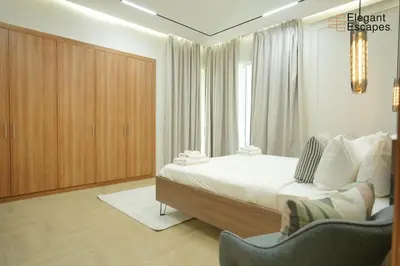 a bedroom with a bed and a chair and a window at Stylish 1B in Heart of Marina Near Attractions in Dubai