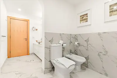 a white bathroom with a toilet and a sink at VayK - Stunning 2BR with Sea View & Beach Access in Dubai