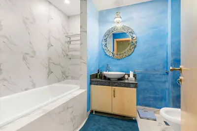 a bathroom with a tub and a sink and a mirror at VayK - Stunning 2BR with Sea View & Beach Access in Dubai