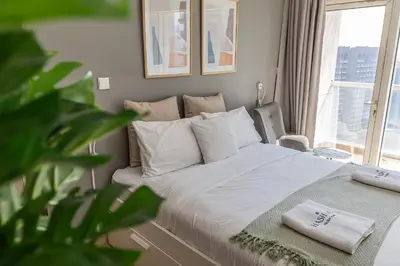 a bedroom with a bed with a plant and a window at Burj Nujoom I Studio I Downtown in Dubai
