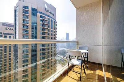 a balcony with chairs and a view of a city at Burj Nujoom I Studio I Downtown in Dubai