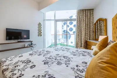 a bedroom with a bed and a tv and a window at Millennium Binghatti Studio I Business bay I Studio in Dubai