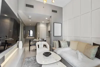 a living room with a white couch and a table at Sleek 1-Bedroom Getaway in Zada Tower in Dubai