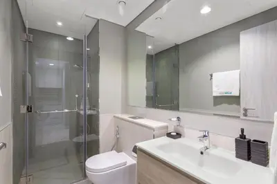 a bathroom with a toilet and a sink and a shower at Sleek 1-Bedroom Getaway in Zada Tower in Dubai