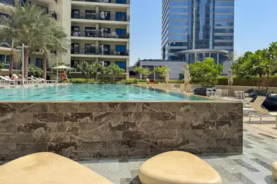 a swimming pool in a resort with buildings in the background at Sleek 1-Bedroom Getaway in Zada Tower in Dubai