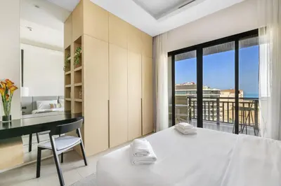 a bedroom with a bed and a desk with a view at VayK - Great Escape at Anantara The Palm Residences in Dubai