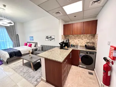 a kitchen and living room with a bed in a room at Enjoy our feel-home Appartement in Dubai