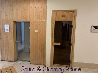 two wooden doors in a room with a toilet at Enjoy our feel-home Appartement in Dubai
