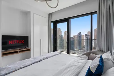 a bedroom with a bed and a large window at VayK - Sleek & Stylish 1BR in Vida Dubai Marina in Dubai