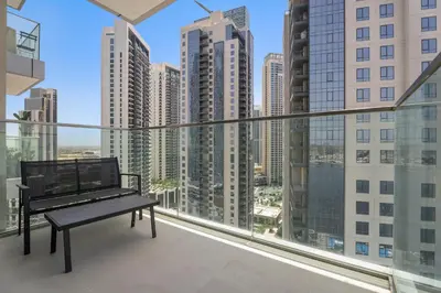 a balcony with a bench and a view of the city at Vayk - Bright & Elegant 2BR Apartment with Creek Views in Dubai