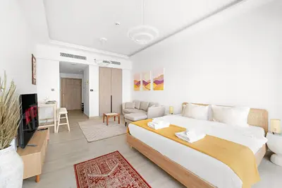a bedroom with a large bed and a living room at VayK - Comfortable Studio in JLT with Amazing Amenities in Dubai