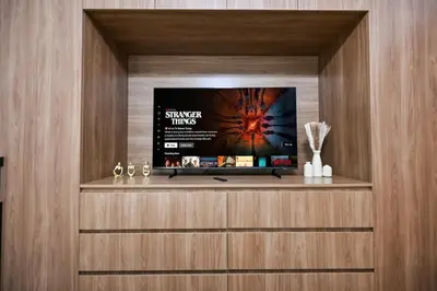 a flat screen tv sitting on top of a wooden wall at Golden Stays - Brand New JVC Studio I Modern & Fully Furnished in Dubai