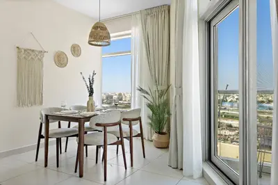 a dining room with a table and chairs and a window at VayK - Modern 1BR apartment in the Heart of Downtown Dubai in Dubai