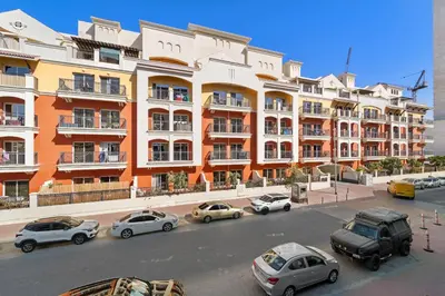 a group of cars parked in front of a large building at VayK - Contemporary and Cozy Studio in the Heart of JVC in Dubai