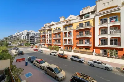 a city street with cars parked in front of buildings at VayK - Contemporary and Cozy Studio in the Heart of JVC in Dubai