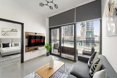 a living room with a couch and a large window at VayK - Modern 1BR Apartment in Business Bay in Dubai