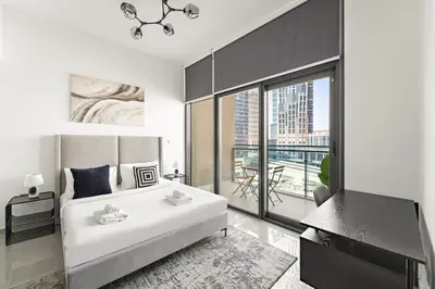 a bedroom with a large white bed and a balcony at VayK - Modern 1BR Apartment in Business Bay in Dubai