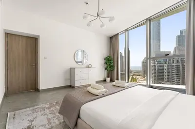 a white bedroom with a large bed and large windows at VayK - Ocean View 1BR in the Heart of Dubai Marina in Dubai