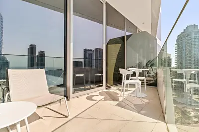 a balcony with white chairs and tables on a building at VayK - Ocean View 1BR in the Heart of Dubai Marina in Dubai