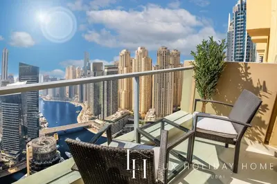 a balcony with two chairs and a view of the city at LUX The JW Marina Suite 3 in Dubai