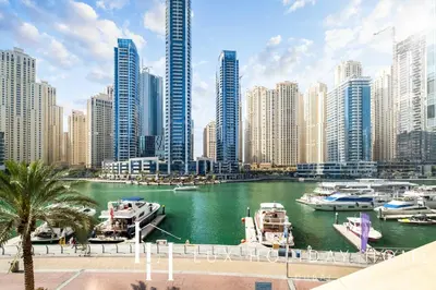 a river with boats in a city with tall buildings at LUX The JW Marina Suite 3 in Dubai