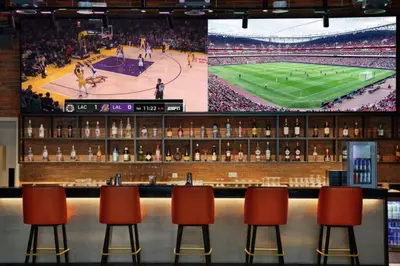 a stage with chairs and a screen with a basketball game at Highend Seven Palm 1BR Private Beach and Infinity Pool in Dubai