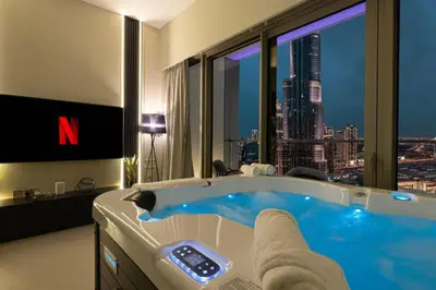 a bathroom with a tub with a view of a city at SkyHigh Luxury 2BR Burj View Private Hot Tub Walk to DubaiMall in Dubai