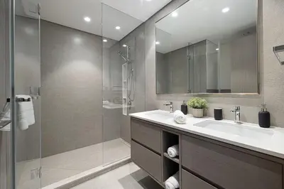 a bathroom with a sink and a glass shower at SkyHigh Luxury 2BR Burj View Private Hot Tub Walk to DubaiMall in Dubai