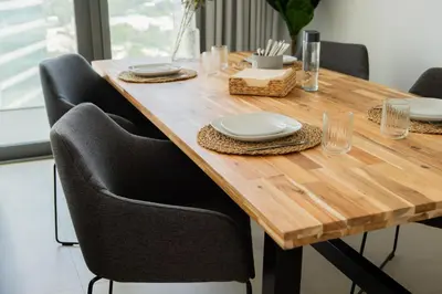 a wooden table with black chairs and a wooden table with plates at Elite Escape Holiday Home - 1 BHK Getaway with Dubai Mall Access - 3310 in Dubai