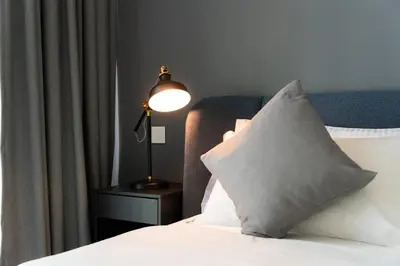 a bedroom with a bed with a lamp and a pillow at Elite Escape Holiday Home - 1 BHK Getaway with Dubai Mall Access - 3310 in Dubai