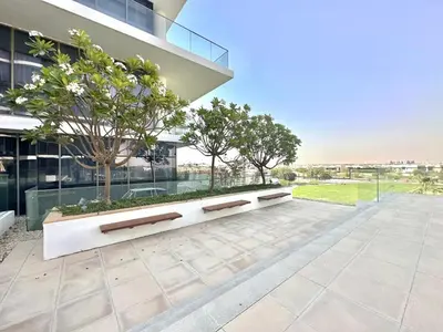 an empty bench in front of a building at Bright & Airy 2BR Full Park View in Dubai