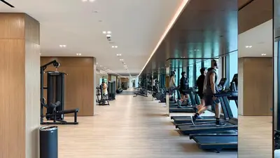 a gym with people on treadmills in a building at Cozy Apartment Gym Pool High 17th Floor JVC Gateway to Dubai in Dubai