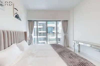 a bedroom with a bed and a large window at Brand New & Modern 1BR Apartment in Dubai