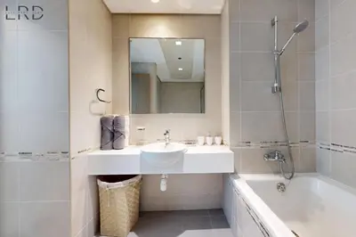 a bathroom with a sink and a tub and a mirror at Brand New & Modern 1BR Apartment in Dubai