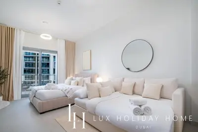 a white living room with a couch and a mirror at LUX Dubai Hills Sway Studio 2 in Dubai
