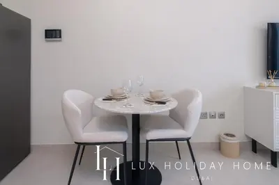 a dining room with a white table and chairs at LUX Dubai Hills Sway Studio 2 in Dubai