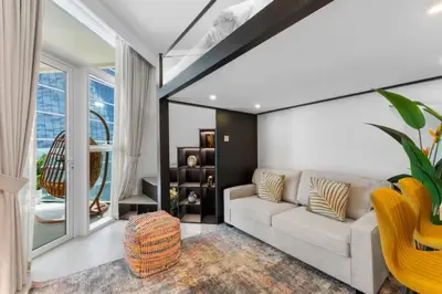 a living room with a white couch and a large window at Luxe Studio Loft Type - Canal View - Fully Furnished in Dubai
