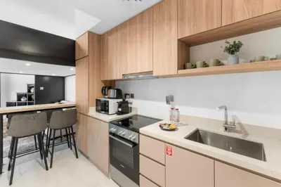 a kitchen with a sink and a stove top oven at Loft-Style Studio - Canal View - Fully Furnished - Near Dubai Mall - Burj Khalifa in Dubai