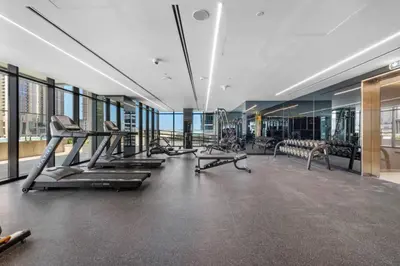 a gym with treadmills and machines in a building at Loft-Style Studio - Canal View - Fully Furnished - Near Dubai Mall - Burj Khalifa in Dubai