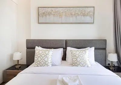 a bedroom with a large bed with white sheets and pillows at Waterfront 1BR - Canal View - Fully Furnished in Dubai